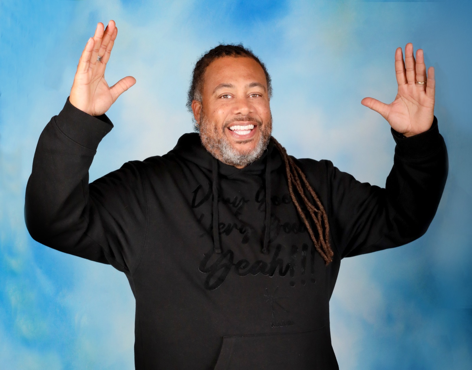 Dr. Harvey Hinton III, arms raised, laughing.